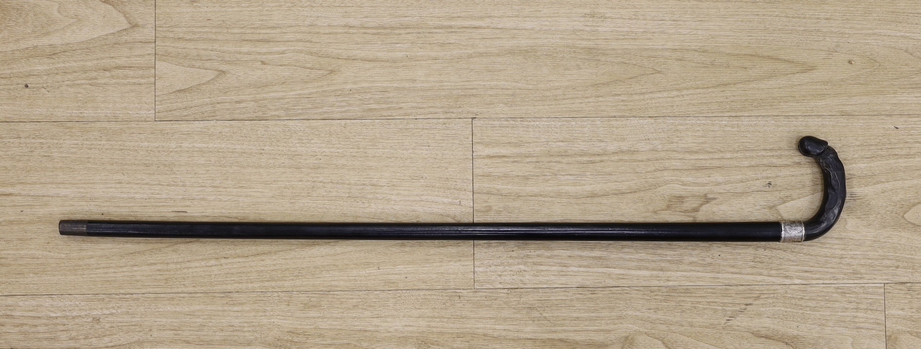 A silver mounted ebony cane with a phallic shaped handle, presented by N.D.T. Chapel to W.H. Miles, 1899. 82cm high